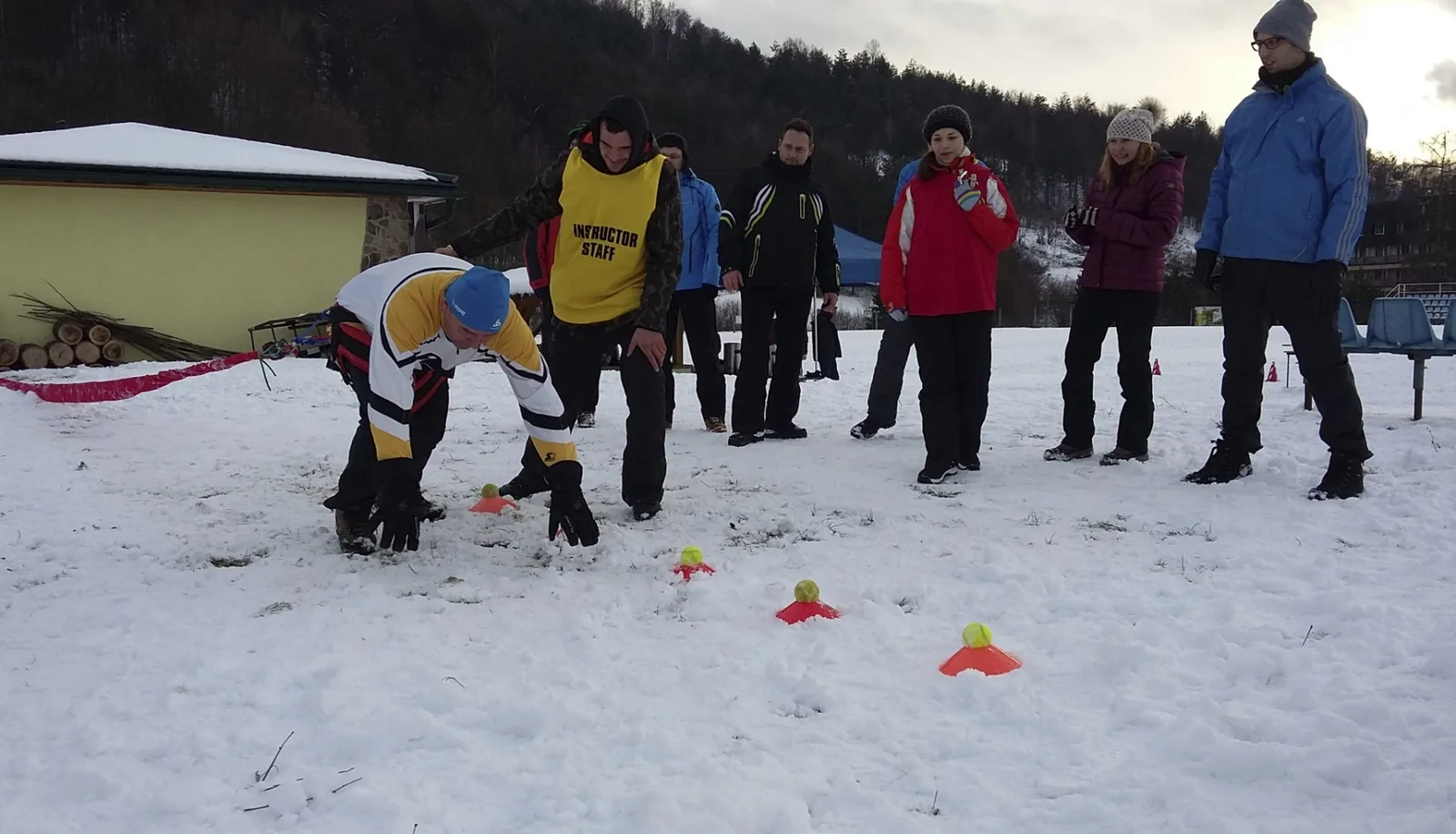 Účastník skúša pohybovú úlohu v snehovom areáli pred skupinou