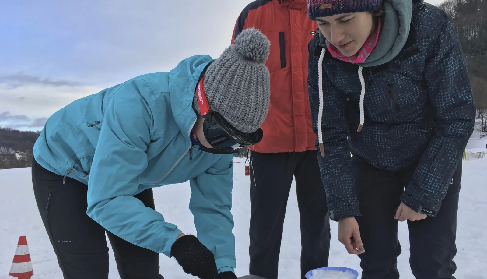 Dvaja účastníci sa sústreďujú na spoločnú úlohu vonku v zime