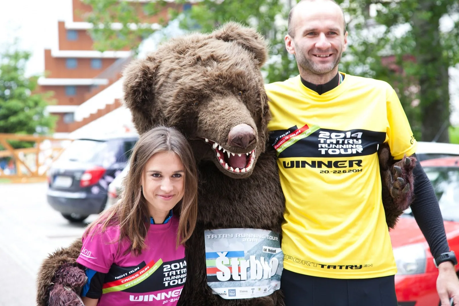 Maskot medveď Štrbko pri spoločnom fotení s dvoma účastníkmi