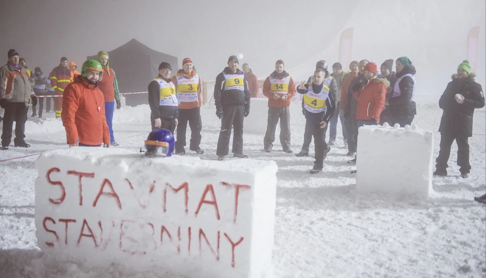 Účastníci zimného outdoorového podujatia pri ľadovom bloku s nápisom Stavmat Stavebniny